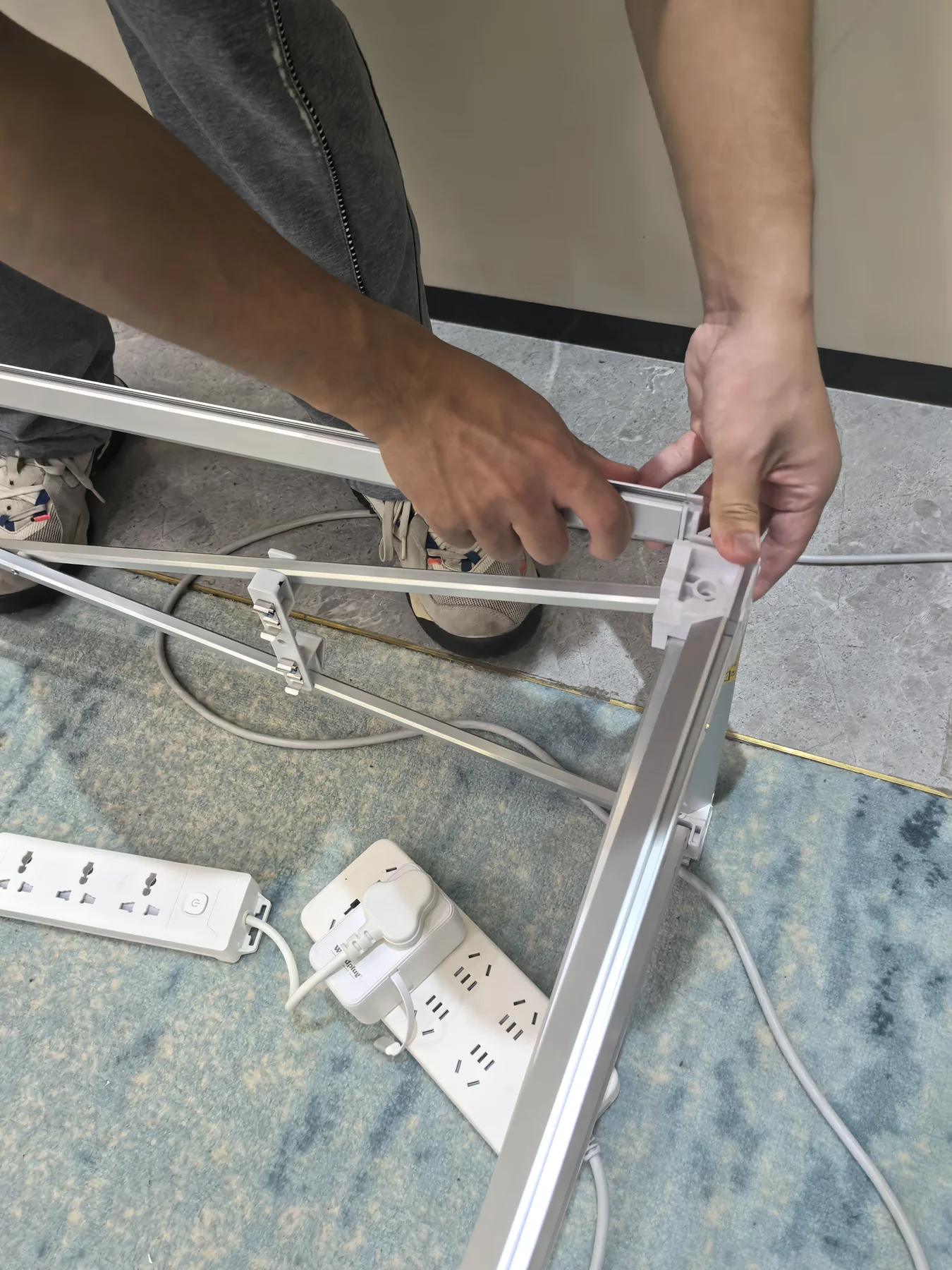QuicklyShow technician checking the aluminum frame connection on a US customer's 3 m pop-up lightbox before shipment