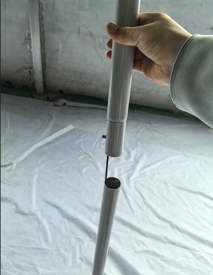 Internal elastic cord linking two separated aluminum tube sections.