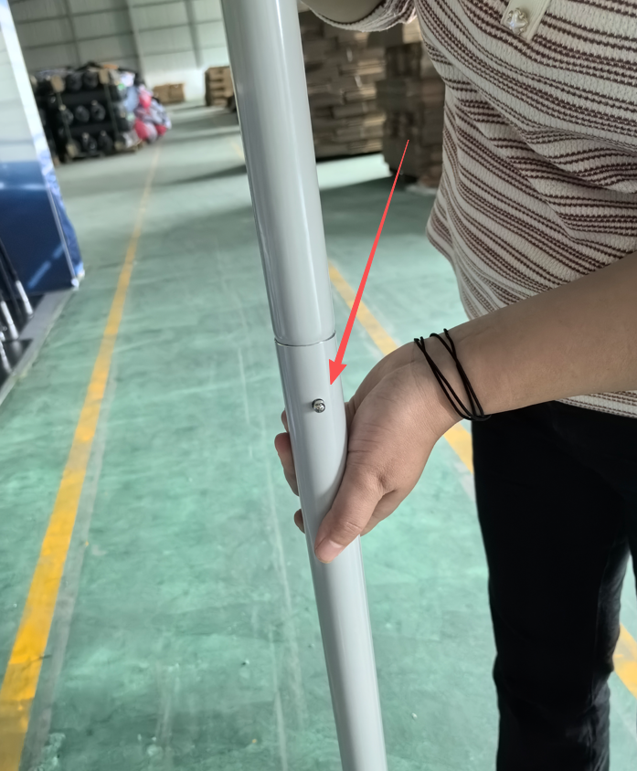 Connected aluminum tube sections with the locking button projecting through its receiving hole.