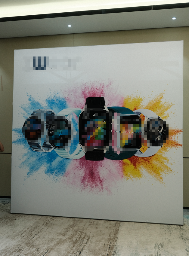 Completed freestanding display wall with a white printed graphic featuring watches and colorful artwork.